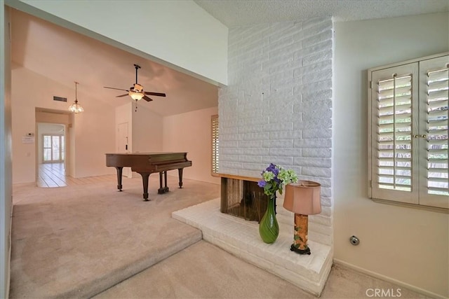 recreation room with a textured ceiling, ceiling fan, lofted ceiling, and carpet floors