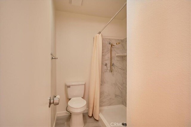 bathroom with a shower with curtain and toilet