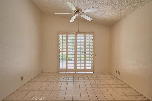 empty room featuring lofted ceiling, light tile patterned floors, ceiling fan, and a textured ceiling