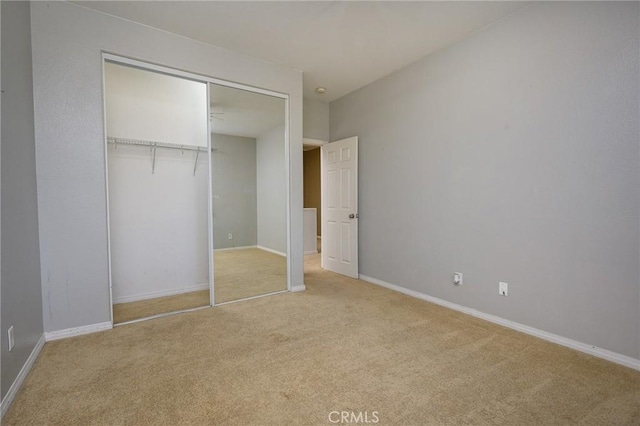 unfurnished bedroom featuring a closet and light colored carpet