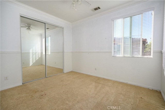 unfurnished bedroom with ceiling fan, light colored carpet, multiple windows, and a closet