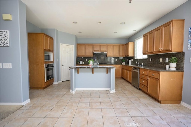 kitchen with decorative backsplash, appliances with stainless steel finishes, a breakfast bar, and a kitchen island