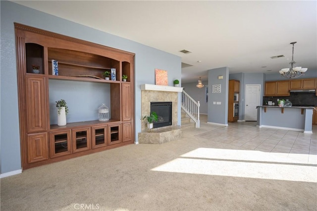 carpeted living room with a premium fireplace and an inviting chandelier