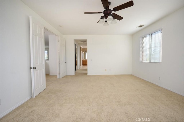 carpeted spare room featuring ceiling fan