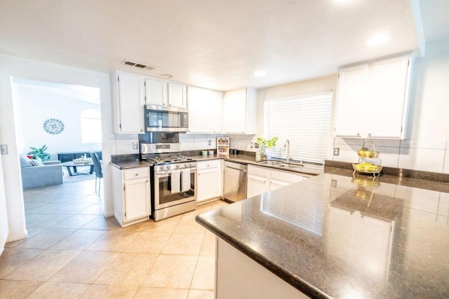 kitchen featuring appliances with stainless steel finishes, sink, tasteful backsplash, and white cabinetry