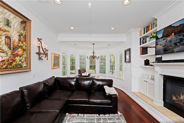 living room featuring crown molding, an inviting chandelier, built in features, and dark hardwood / wood-style flooring