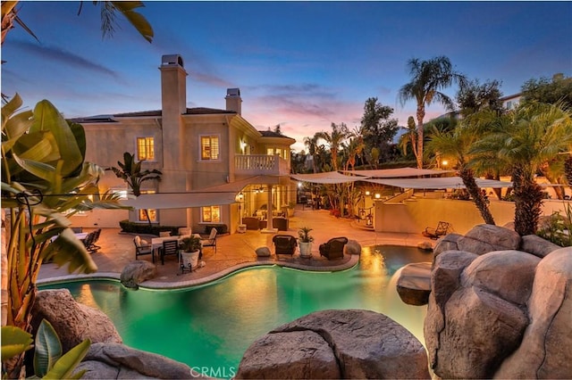 pool at dusk featuring a patio