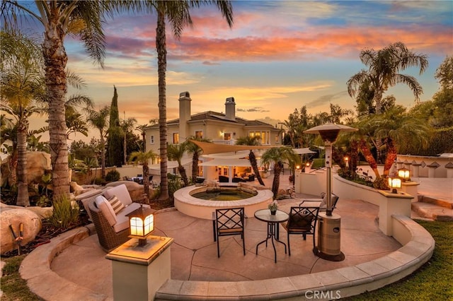 patio terrace at dusk featuring an outdoor fire pit