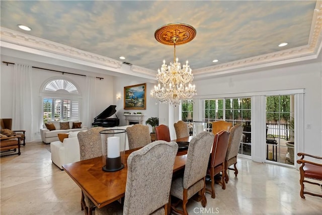 dining room with crown molding, an inviting chandelier, and a tray ceiling