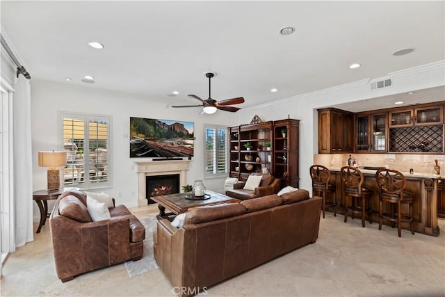 living room featuring crown molding, plenty of natural light, and bar area