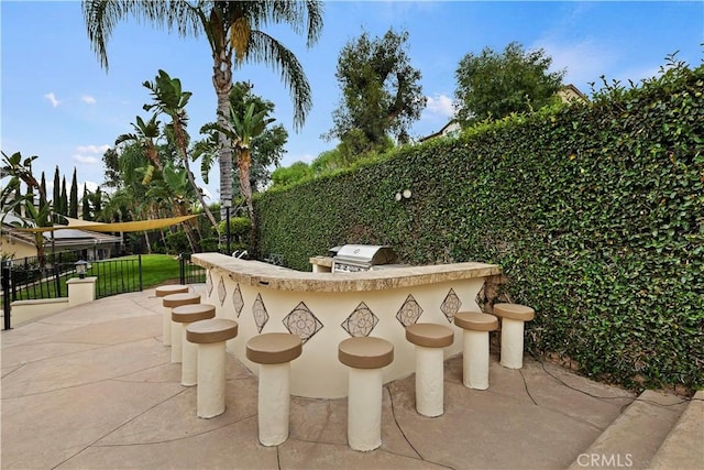 view of patio featuring a grill, area for grilling, and an outdoor bar