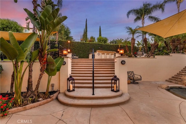 gate at dusk with a patio area