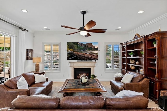 living room featuring ceiling fan, ornamental molding, and a healthy amount of sunlight