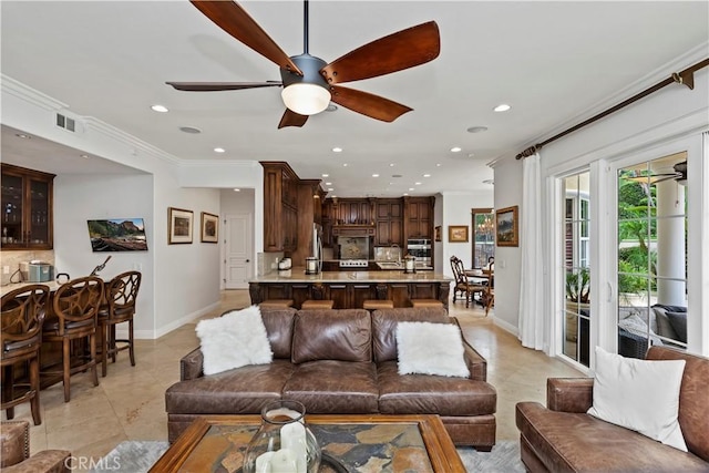 living room featuring ceiling fan and ornamental molding