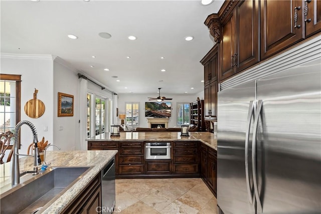 kitchen featuring crown molding, stainless steel appliances, sink, and light stone counters