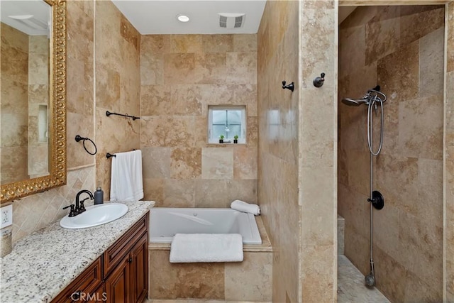 bathroom with vanity, tile walls, and plus walk in shower