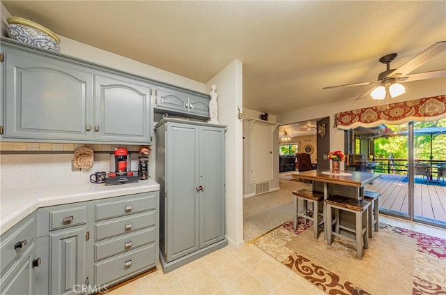 kitchen featuring gray cabinetry, ceiling fan, and light tile patterned flooring