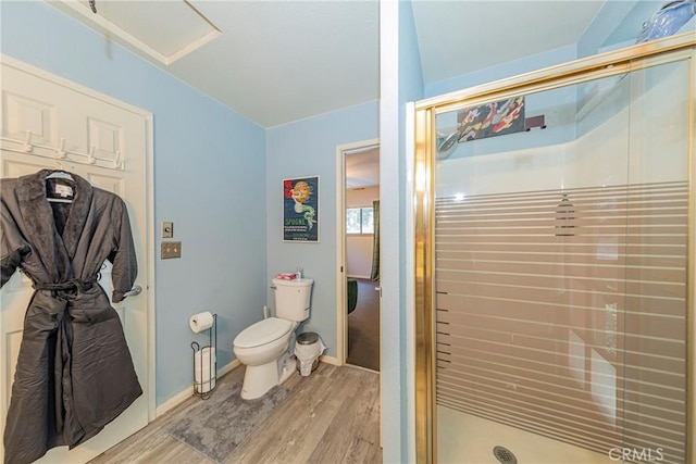 bathroom with hardwood / wood-style floors, a shower with door, and toilet