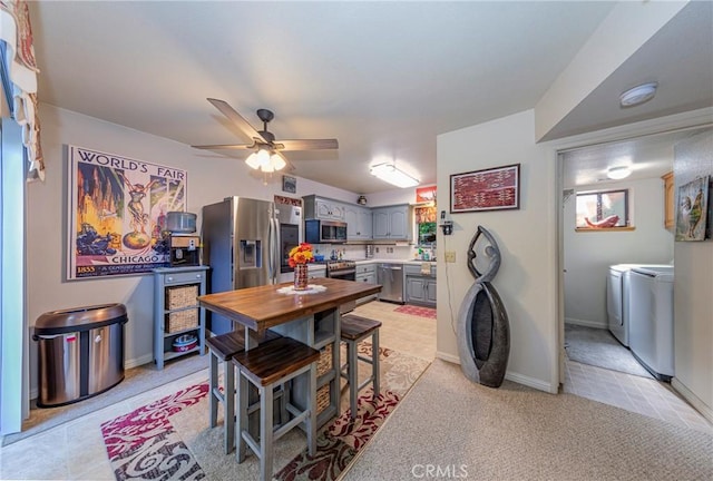 carpeted dining space with ceiling fan and independent washer and dryer