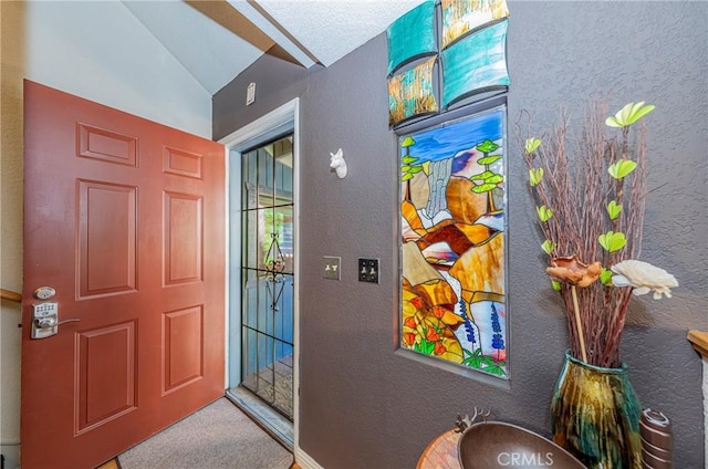 foyer entrance with carpet flooring and lofted ceiling