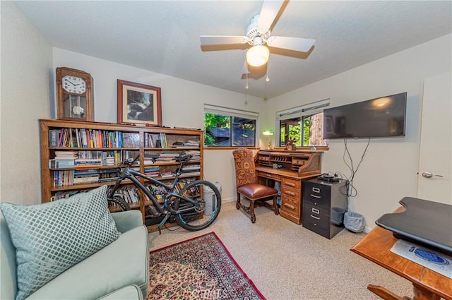 carpeted office space featuring ceiling fan