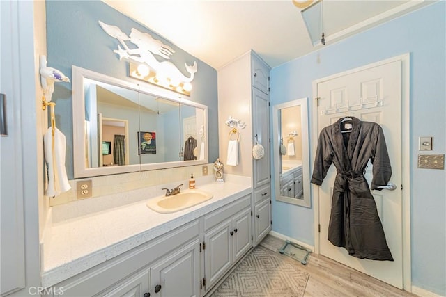 bathroom with hardwood / wood-style flooring, vanity, and tasteful backsplash