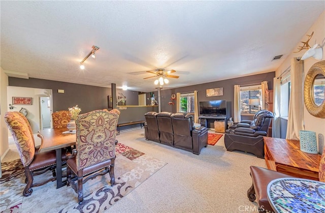 living room featuring ceiling fan, light colored carpet, and rail lighting