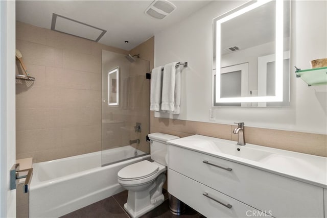 full bathroom with tiled shower / bath, vanity, toilet, and tile patterned floors