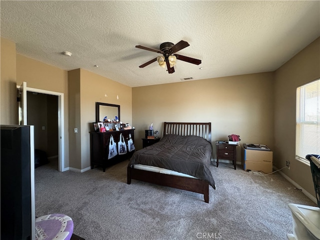 carpeted bedroom with ceiling fan and a textured ceiling