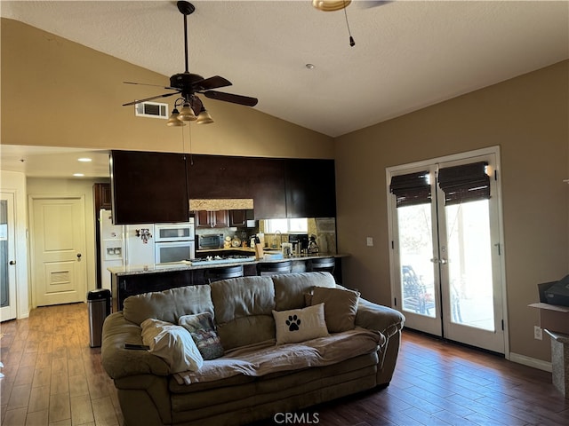 living room featuring ceiling fan, a textured ceiling, lofted ceiling, and light hardwood / wood-style floors