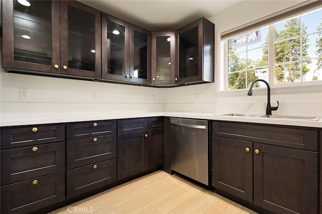 kitchen with dishwasher, light countertops, dark brown cabinets, and a sink