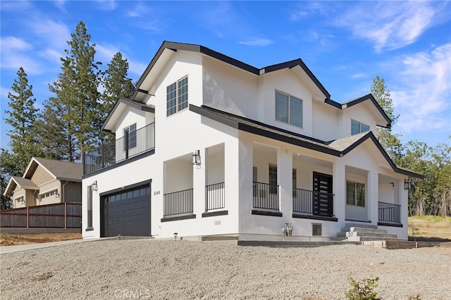 modern farmhouse style home featuring stucco siding, a garage, and covered porch