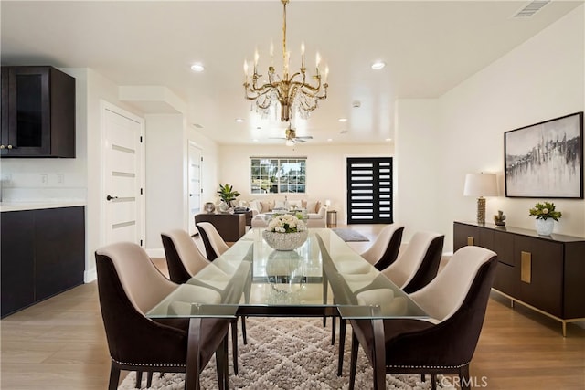 dining room with light wood finished floors, visible vents, recessed lighting, and an inviting chandelier