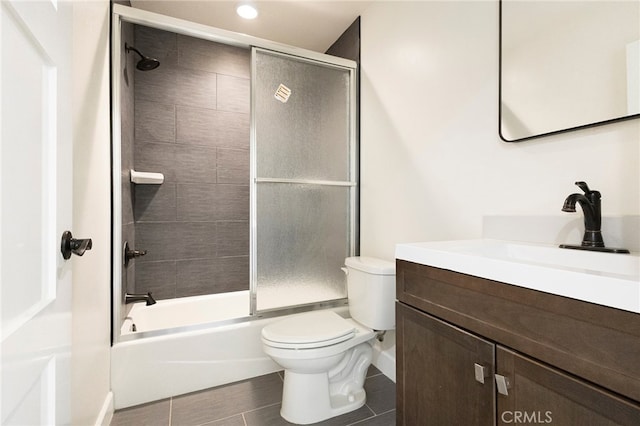 bathroom with combined bath / shower with glass door, toilet, and vanity