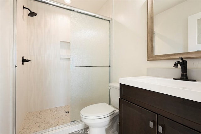 bathroom with toilet, a stall shower, and vanity