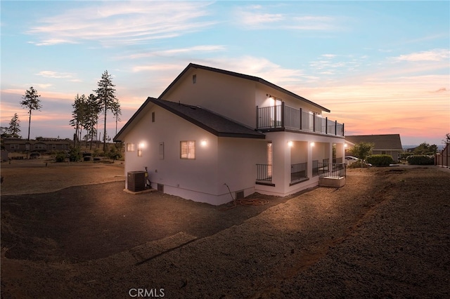 view of property exterior featuring central air condition unit, a balcony, and stucco siding