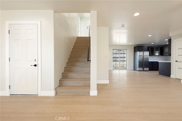 staircase with recessed lighting, wood finished floors, and baseboards