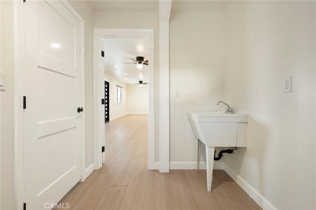 corridor featuring baseboards and light wood-type flooring