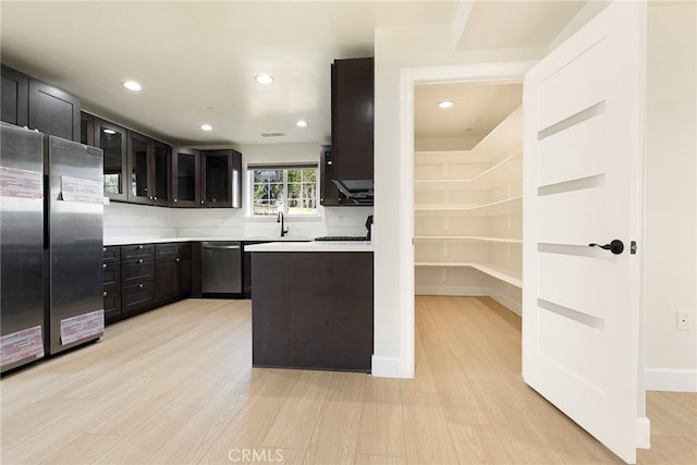 kitchen featuring light countertops, light wood-style floors, appliances with stainless steel finishes, and a sink