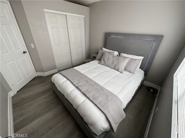 bedroom with dark hardwood / wood-style floors and a closet