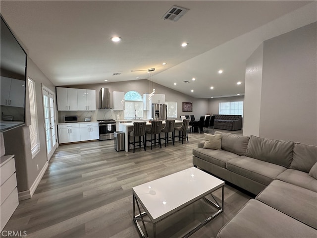 living room with light hardwood / wood-style flooring and lofted ceiling