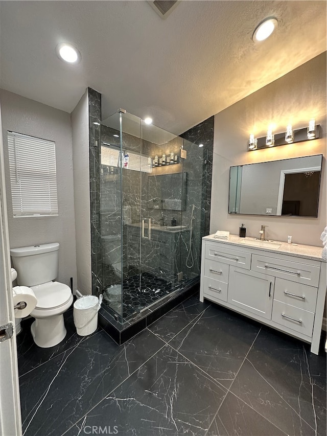 bathroom with vanity, toilet, and a shower with door