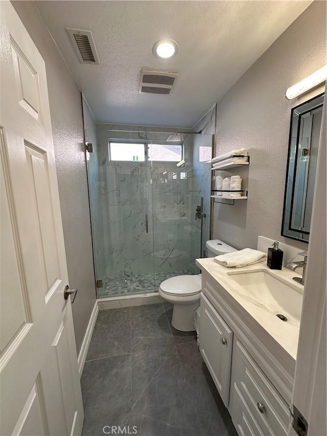 bathroom with walk in shower, vanity, toilet, and a textured ceiling