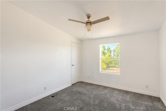 carpeted spare room with ceiling fan