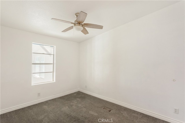 unfurnished room with dark colored carpet, ceiling fan, and baseboards