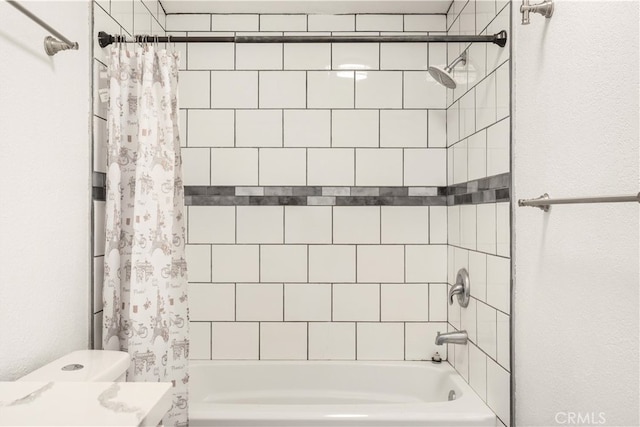 bathroom featuring shower / tub combo and toilet