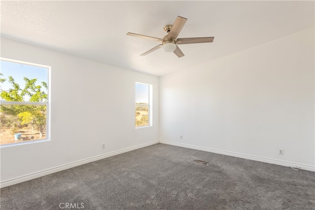 carpeted spare room featuring ceiling fan, a textured ceiling, visible vents, and baseboards