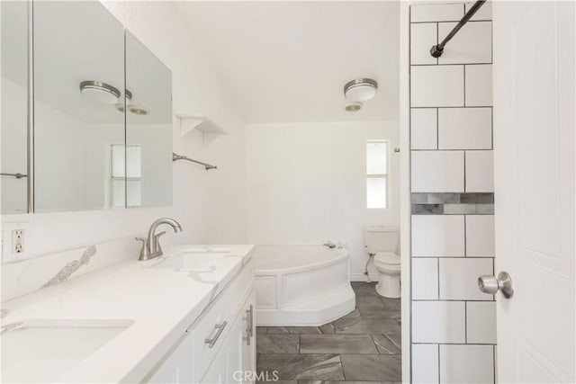 full bath featuring a garden tub, a sink, toilet, and double vanity