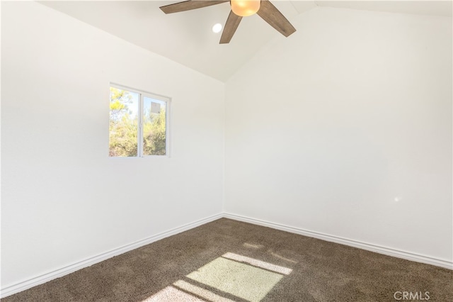 carpeted empty room with lofted ceiling, baseboards, and a ceiling fan