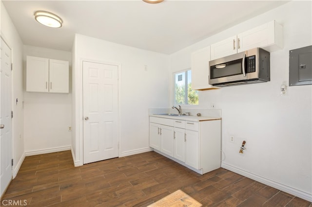 kitchen featuring white cabinets, electric panel, dark hardwood / wood-style floors, and sink